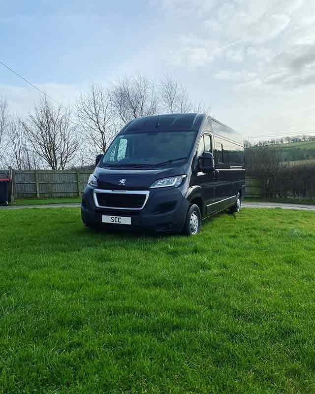 woman's legs sticking out the front window of a campervan