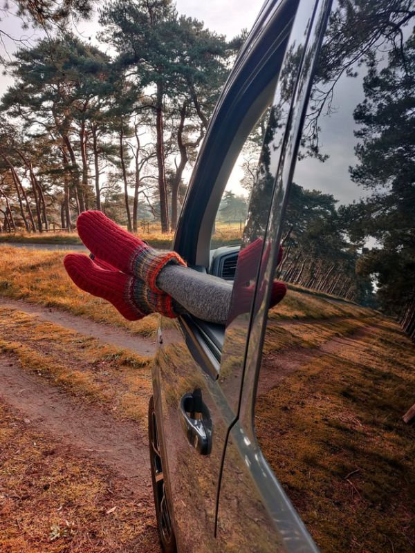 woman's legs sticking out the front window of a campervan